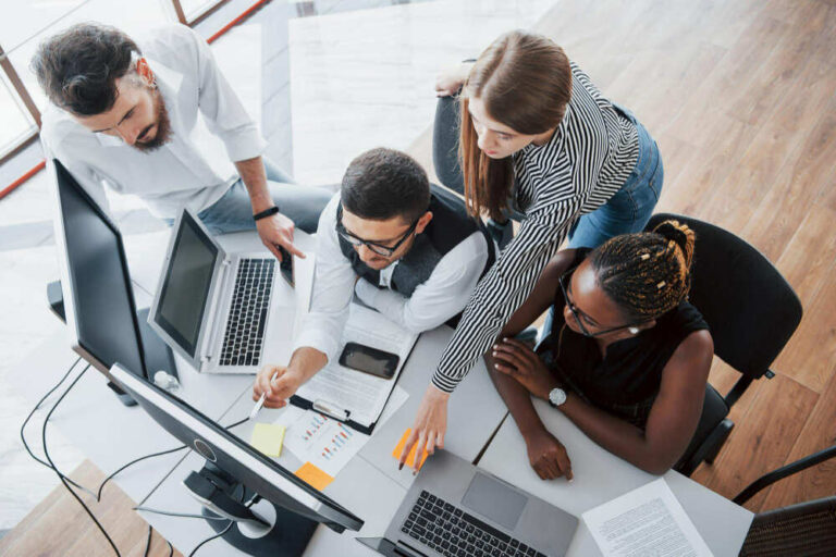 vue du dessus sur une équipe de professionnels devant un écran d'ordinateur